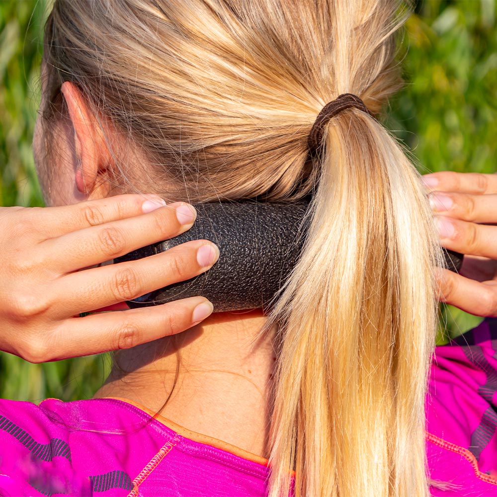 Frau bei Massage mit Faszienrolle